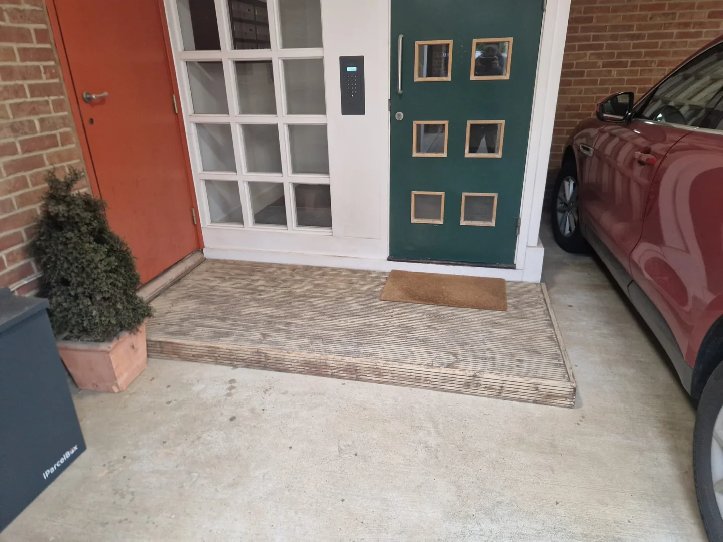 Weathered timber decking at the communal entrance to 8–11 Lindel Court.