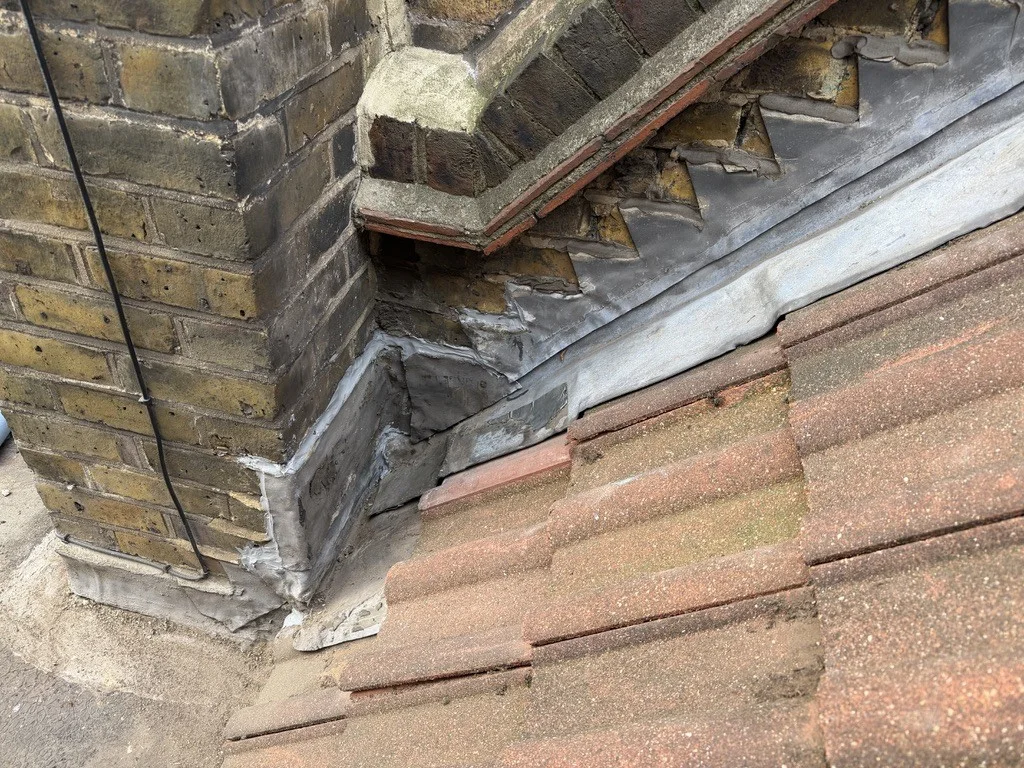 Completed leadwork at the chimney and adjoining roof junction.