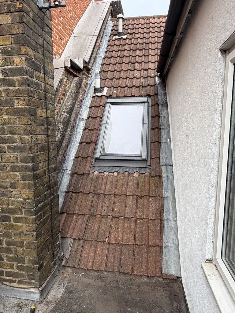 Roof investigation, replacement roofing layers and leadwork repairs around a rooflight, parapet wall and chimney.